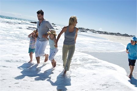 simsearch:6108-05858472,k - Parents and three children walking on the beach, outdoors Stock Photo - Premium Royalty-Free, Code: 6108-05858104
