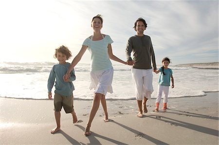 simsearch:877-06832467,k - Parents and two children walking on the beach, outdoors Stock Photo - Premium Royalty-Free, Code: 6108-05858132