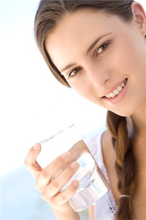 face woman glasses - Portrait of a young woman holding a water glass, outdoors Stock Photo - Premium Royalty-Free, Code: 6108-05858369