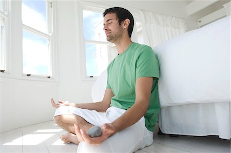 Young man in yoga attitude, indoors Foto de stock - Sin royalties Premium, Código: 6108-05858482