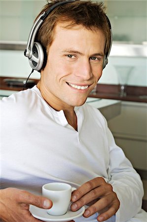 simsearch:6108-05858968,k - Portrait of a young man listening to music with headphones Fotografie stock - Premium Royalty-Free, Codice: 6108-05858588