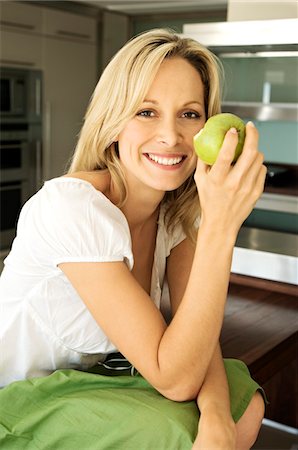 simsearch:6108-05857716,k - Young smiling woman eating an apple Stock Photo - Premium Royalty-Free, Code: 6108-05858509