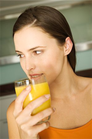 dietary supplements container - Young woman holding glass of orange juice Stock Photo - Premium Royalty-Free, Code: 6108-05858524