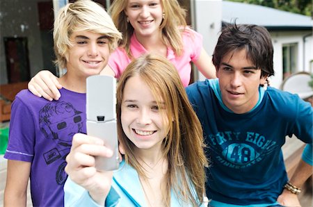 4 teenagers using camera phone Foto de stock - Sin royalties Premium, Código: 6108-05858641