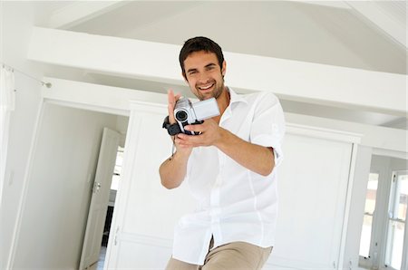 Young man using camcorder Foto de stock - Sin royalties Premium, Código: 6108-05858663