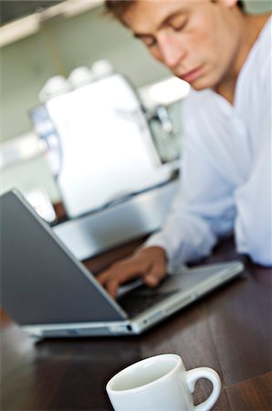 Young man using laptop in kitchen Stock Photo - Premium Royalty-Free, Code: 6108-05858669