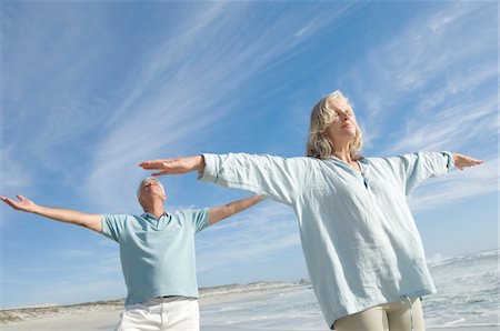 relax man face - Couple with arms out on the beach, eyes closed Stock Photo - Premium Royalty-Free, Code: 6108-05858773