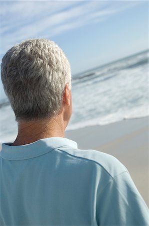 Man looking out to sea, rear view Stock Photo - Premium Royalty-Free, Code: 6108-05858774