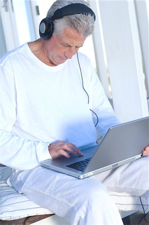 simsearch:6108-05858781,k - Man with headphones using laptop Stock Photo - Premium Royalty-Free, Code: 6108-05858728