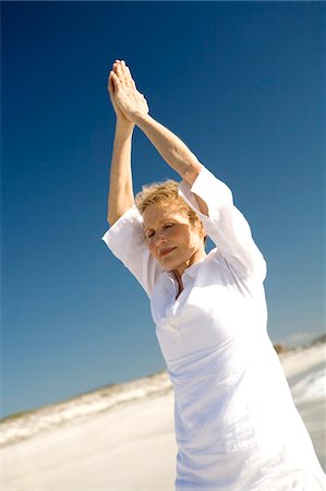Senior woman doing yoga on the beach Stock Photo - Premium Royalty-Free, Code: 6108-05858849