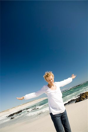 Senior woman with arms out on the beach Foto de stock - Sin royalties Premium, Código: 6108-05858871