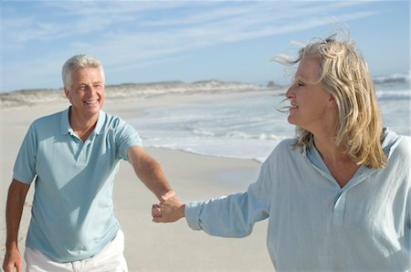 summer season - Couple holding hands, walking on the beach Stock Photo - Premium Royalty-Free, Code: 6108-05858808