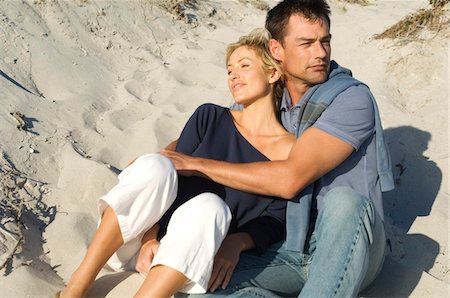 Couple embracing, sitting on the beach Stock Photo - Premium Royalty-Free, Code: 6108-05858963