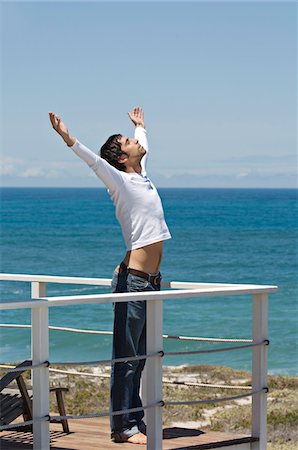 Jeune homme, qui s'étend sur la terrasse, la mer en arrière-plan Photographie de stock - Premium Libres de Droits, Code: 6108-05859058