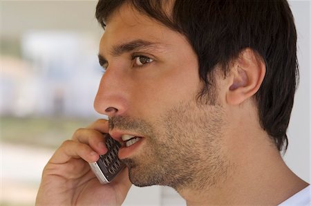 stubble - Portrait of a young man using mobile phone Stock Photo - Premium Royalty-Free, Code: 6108-05859034