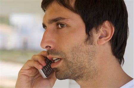 phone worried person - Portrait of a young man using mobile phone Stock Photo - Premium Royalty-Free, Code: 6108-05859034