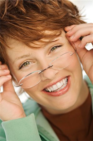 simsearch:6108-05859126,k - Portrait de jeune femme souriante chausser ses lunettes de vue Photographie de stock - Premium Libres de Droits, Code: 6108-05859142