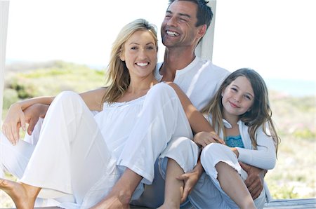 Parents and daughter smiling for the camera, outdoors Stock Photo - Premium Royalty-Free, Code: 6108-05859164