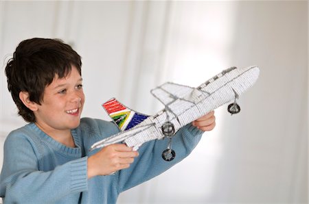 Little boy playing with model aeroplane Foto de stock - Sin royalties Premium, Código: 6108-05859171
