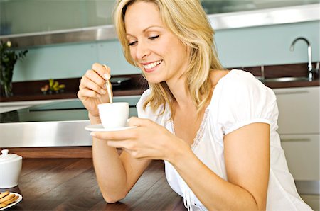 Young smiling woman holding coffee cup Stock Photo - Premium Royalty-Free, Code: 6108-05859113