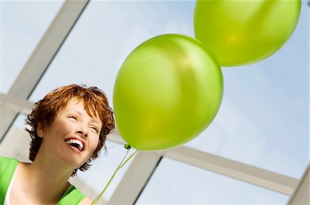 simsearch:6108-05859110,k - Portrait of young smiling woman holding green balloons Stock Photo - Premium Royalty-Free, Code: 6108-05859110