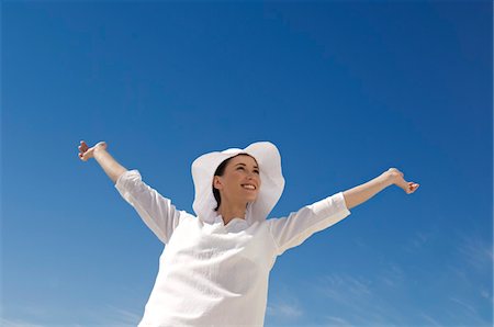 Young woman with arms up, outdoors Stock Photo - Premium Royalty-Free, Code: 6108-05859112