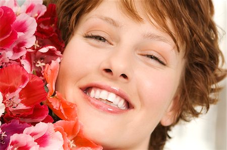 Portrait of smiling woman holding bunch of flowers Stock Photo - Premium Royalty-Free, Code: 6108-05859117