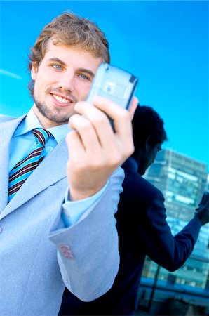 simsearch:6108-05859384,k - Young businessman holding mobile phone Stock Photo - Premium Royalty-Free, Code: 6108-05859271