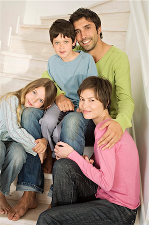 simsearch:6108-05859165,k - Couple and two children smiling for the camera, sitting on stairs Foto de stock - Sin royalties Premium, Código: 6108-05859209