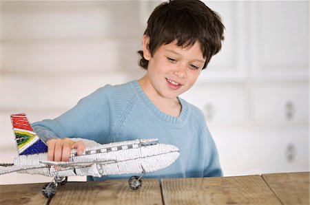 dream and concept - Little boy playing with model aeroplane Stock Photo - Premium Royalty-Free, Code: 6108-05859210