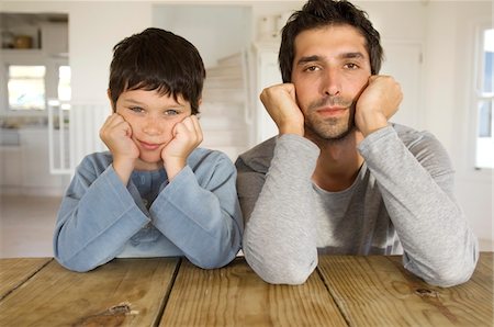 family matching - Father and son looking at camera, with hands on cheeks Stock Photo - Premium Royalty-Free, Code: 6108-05859211