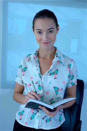 Young woman writing on notebook, portrait Stock Photo - Premium Royalty-Free, Code: 6108-05859218