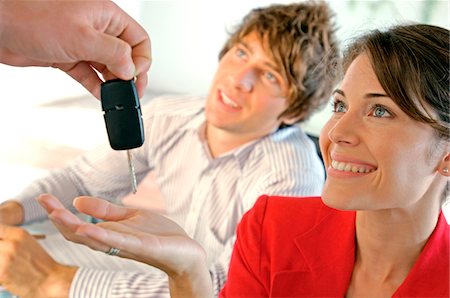 Car dealer handing car key to customer, smiling Foto de stock - Sin royalties Premium, Código: 6108-05859451