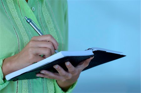 Femme d'affaires détenant bloc-notes avec un stylo, abdomen Photographie de stock - Premium Libres de Droits, Code: 6108-05859409