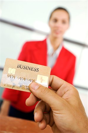 figura - Human hand holding credit card with businesswoman standing in background, close-up Foto de stock - Sin royalties Premium, Código: 6108-05859431