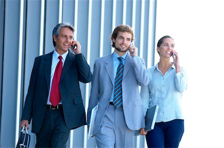 simsearch:6108-05859384,k - Business people using mobile phones, smiling Stock Photo - Premium Royalty-Free, Code: 6108-05859557
