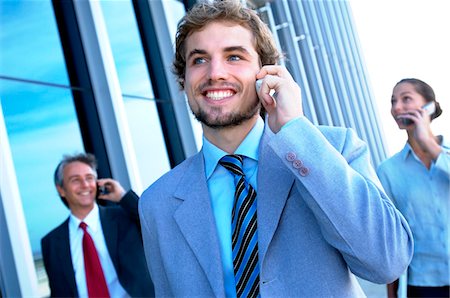 Business people using mobile phones, smiling Stock Photo - Premium Royalty-Free, Code: 6108-05859555