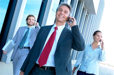 professional phone outside walking - Business people using mobile phone Stock Photo - Premium Royalty-Free, Code: 6108-05859514