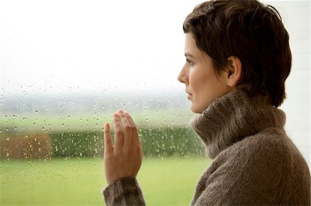 rain drop female - Mid adult woman looking out through a window Stock Photo - Premium Royalty-Free, Code: 6108-05859761