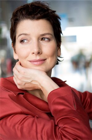 previsión - Close-up of a mid adult woman smiling with her hand on her chin Foto de stock - Sin royalties Premium, Código: 6108-05859739