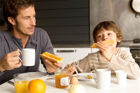 eating family meal in the kitchen - Mid adult man having breakfast with his son Stock Photo - Premium Royalty-Free, Code: 6108-05859877