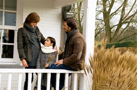 Girl standing and smiling with her parents in a balcony Stock Photo - Premium Royalty-Free, Code: 6108-05859826