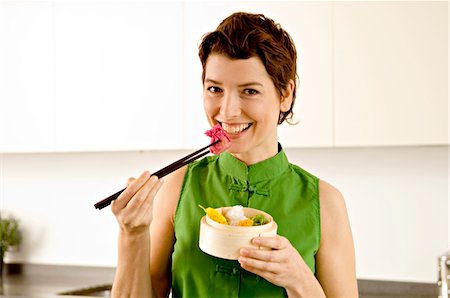 simsearch:6108-05857716,k - Portrait of a mid adult woman eating food with chopsticks Stock Photo - Premium Royalty-Free, Code: 6108-05859977