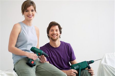 pictures of a man holding a drill - Portrait of a mid adult man and a young woman holding drills Stock Photo - Premium Royalty-Free, Code: 6108-05860081