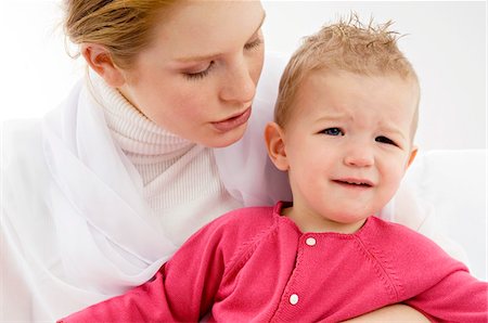 sad adult looking at camera - Close-up of a young woman carrying her crying son Stock Photo - Premium Royalty-Free, Code: 6108-05860177