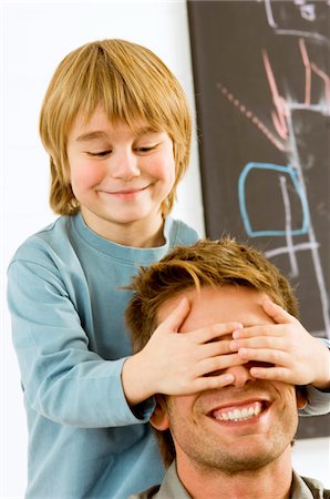 Boy covering eyes of his father Stock Photo - Premium Royalty-Free, Code: 6108-05860279