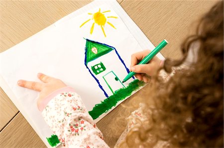 High angle view of a girl coloring on a sheet of paper Stock Photo - Premium Royalty-Free, Code: 6108-05860281