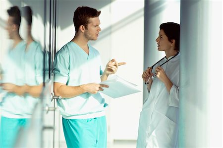 Side profile of two doctors discussing a medical record Stock Photo - Premium Royalty-Free, Code: 6108-05860350