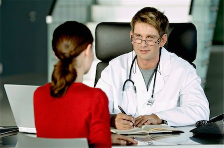 patient doctor talking happy - Male doctor discussing with a female patient in his office Stock Photo - Premium Royalty-Free, Code: 6108-05860383