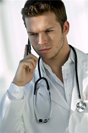 Close-up of a male doctor talking on a mobile phone Stock Photo - Premium Royalty-Free, Code: 6108-05860393